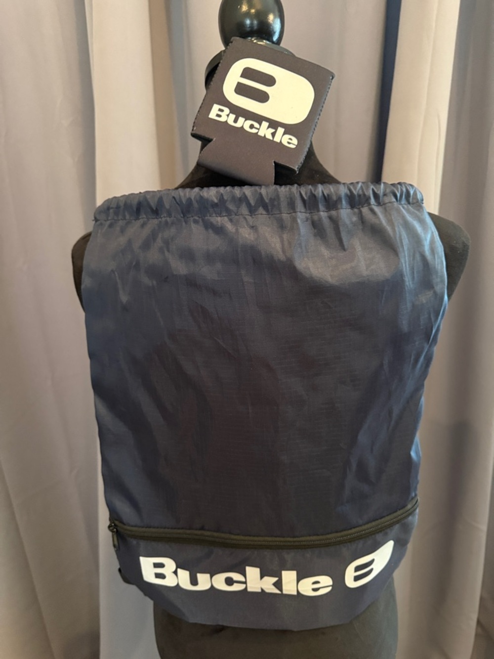 Buckle Navy Drawstring Pack with Front Zip and White Logo and Buckle Coozie.